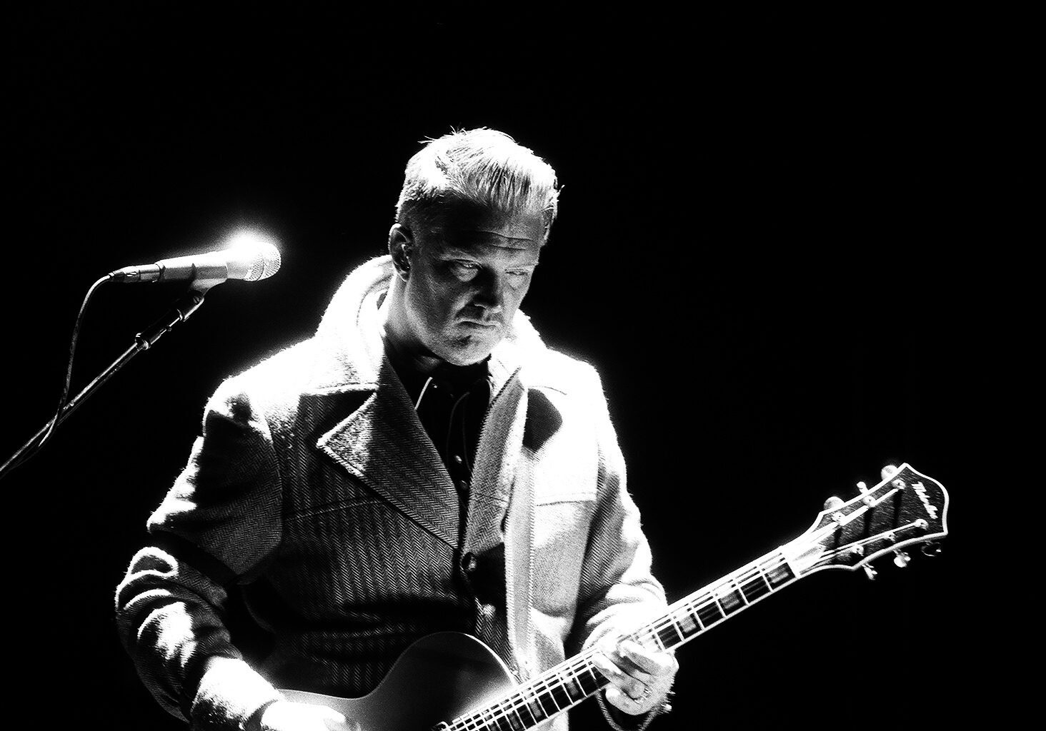 Guitarist performing on stage in black and white.