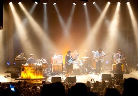 Band performing on stage with bright lights.