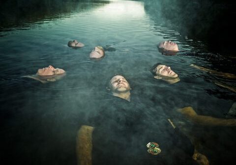 People floating in a misty lake.