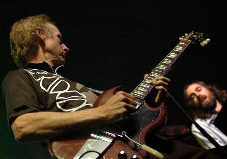 Guitarist playing passionately on stage.