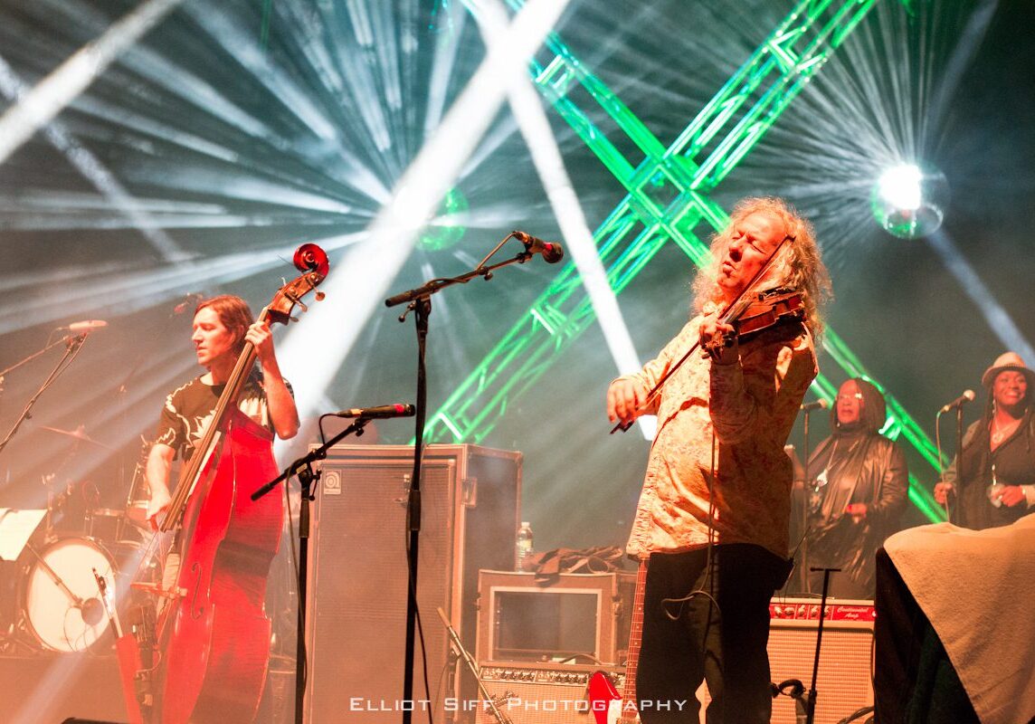 Musicians performing on stage with colorful lights.