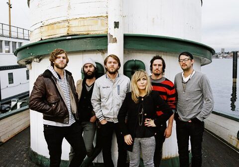Band posing on a boat deck.