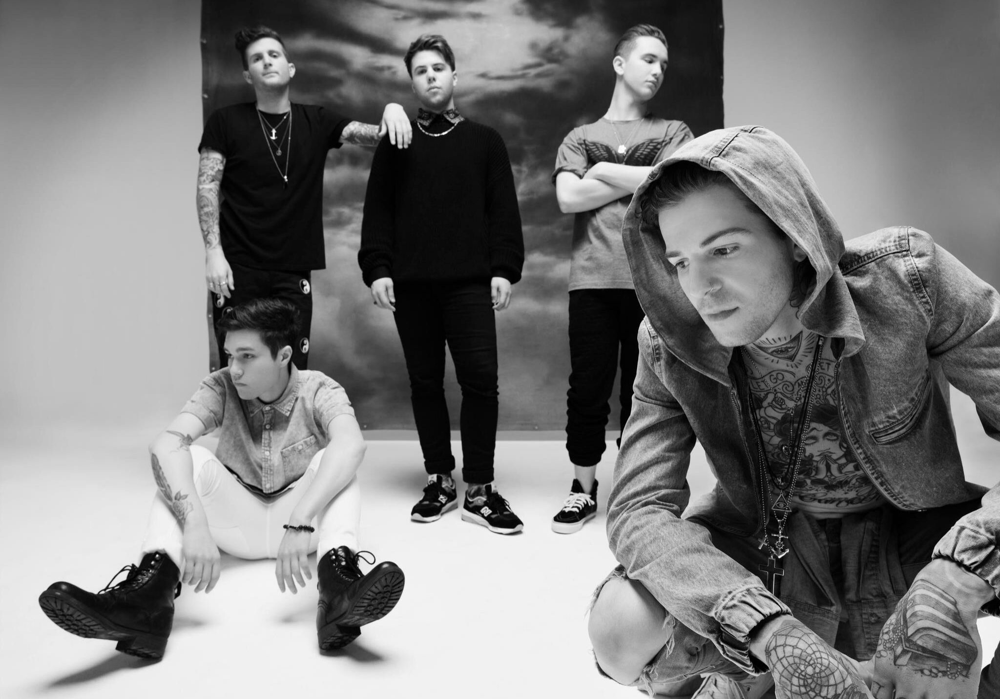 Five people posing in a studio setting.