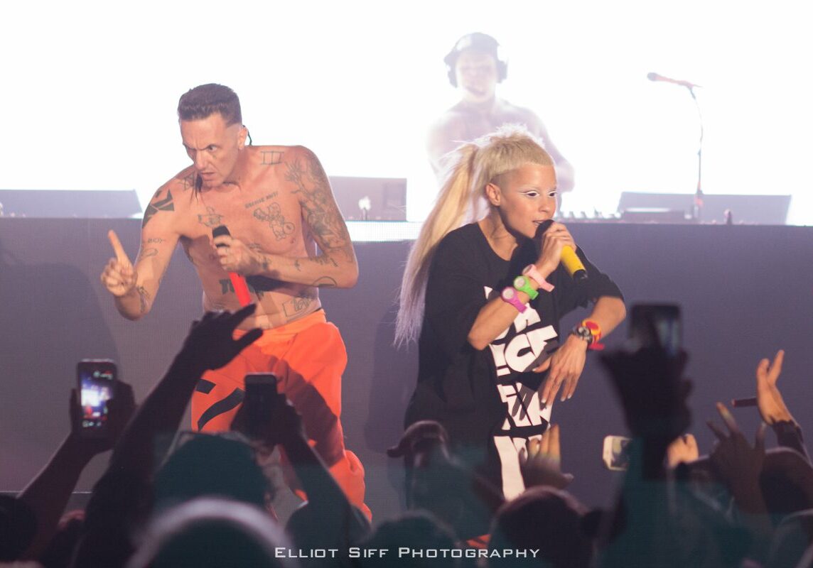 Performers on stage with microphones, vibrant atmosphere.