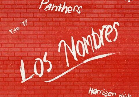 Red brick wall with graffiti-style text.
