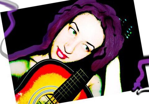 Person with purple hair holding a guitar.