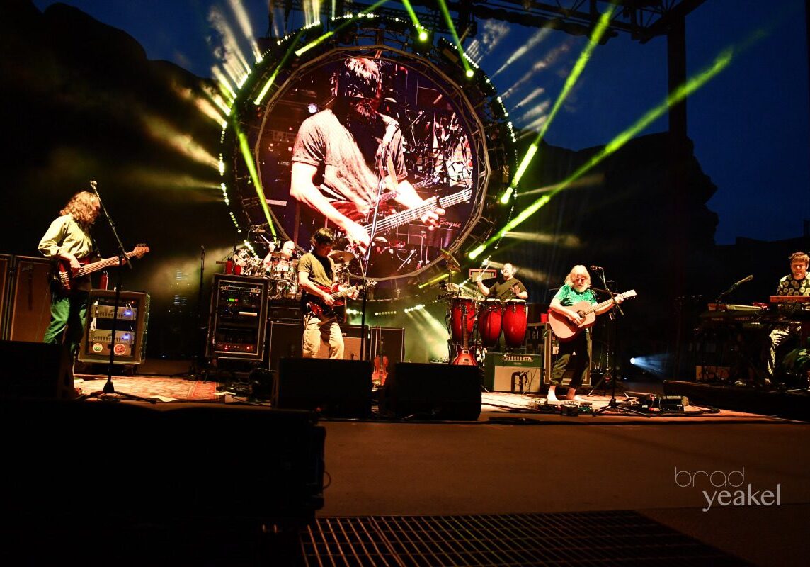 Band performing on stage with vibrant lights.