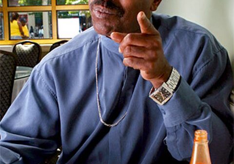Man pointing while eating a meal.