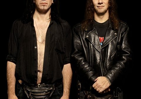 Two men in black leather outfits.