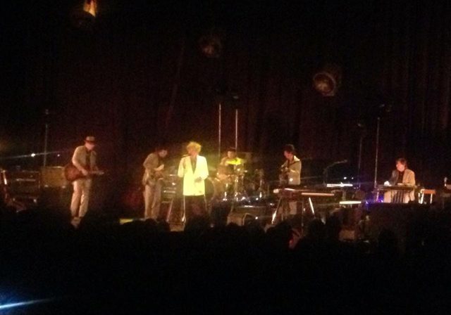 Band performing on stage with instruments.