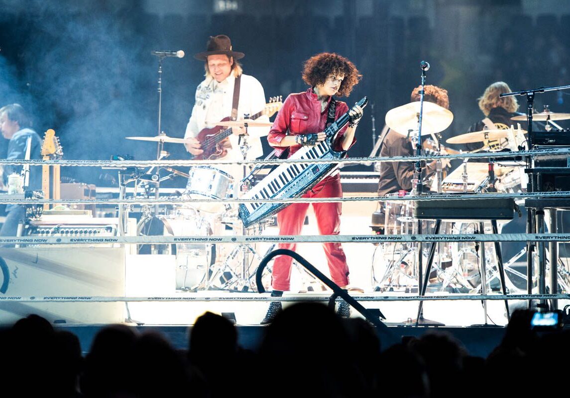 Band performing live on stage with instruments.