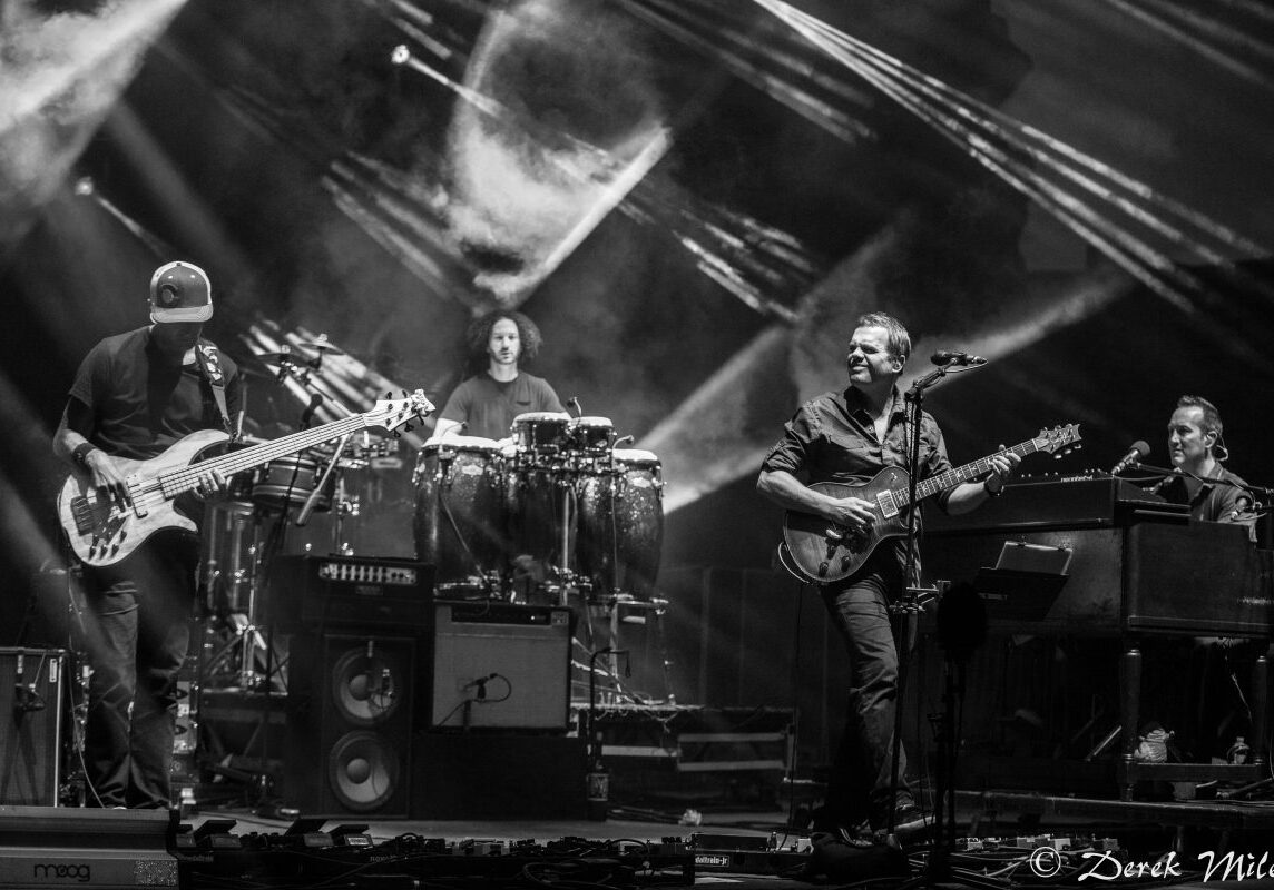 Band performing on stage with instruments.