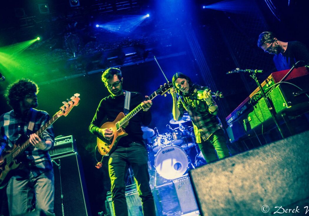 Band performing live on stage with instruments.