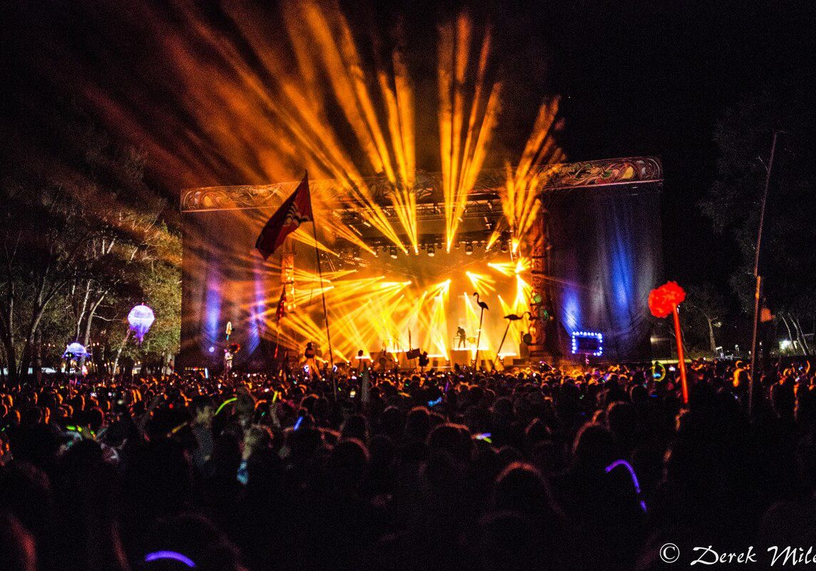 Outdoor concert with vibrant stage lights.