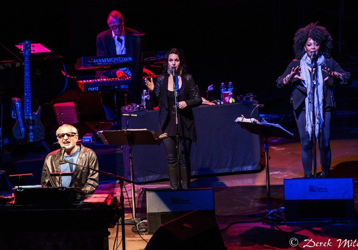 Musicians performing on stage with instruments.