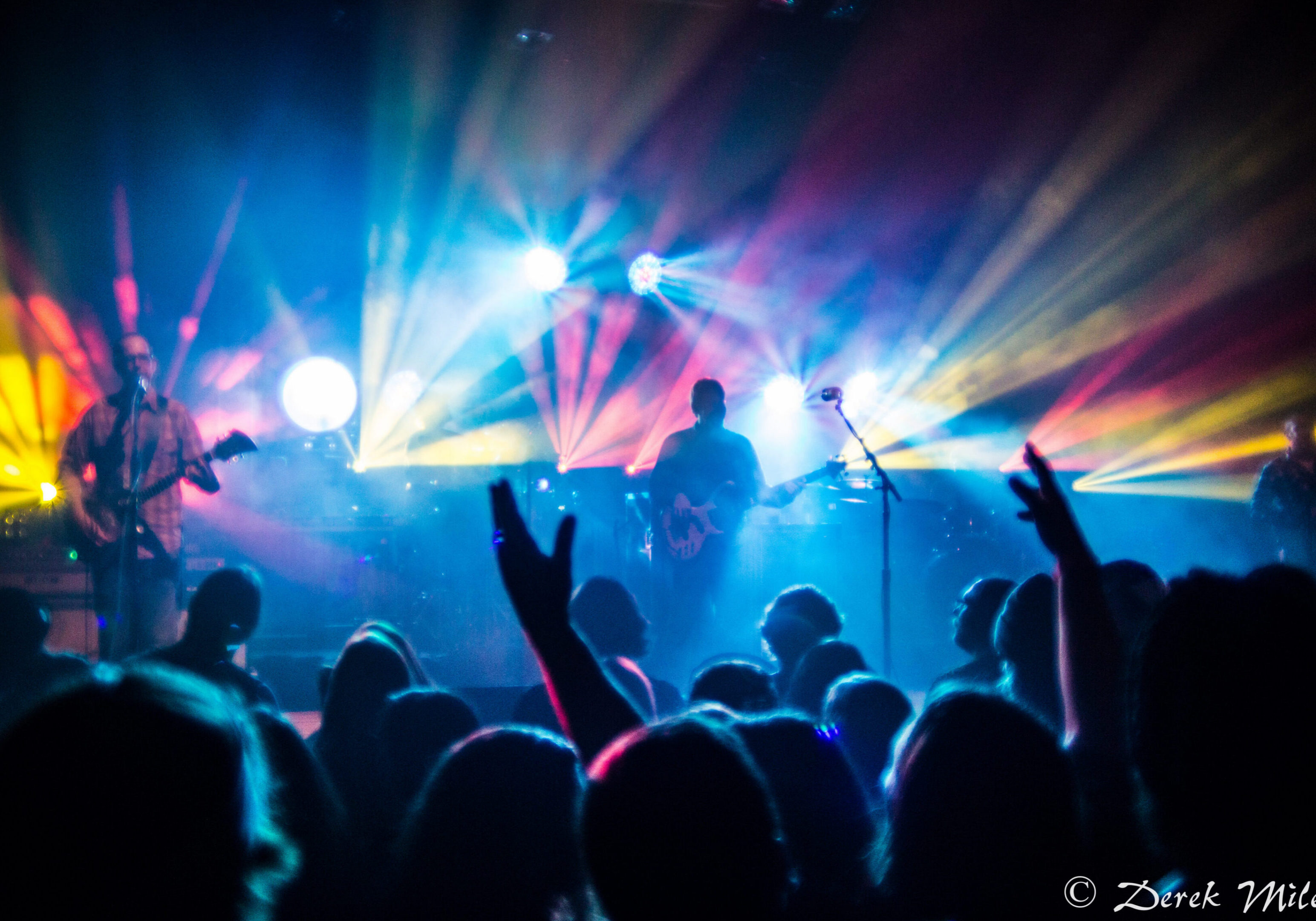 Concert with colorful stage lights and crowd.