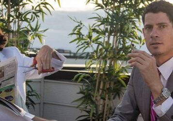 Two men in suits on a terrace.