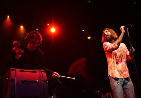 Musicians performing on stage with instruments.
