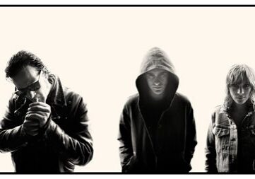 Three people in dark, silhouetted attire.