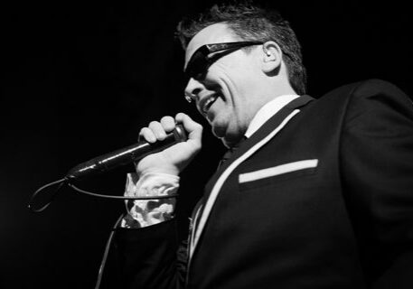 Singer performing on stage with microphone.