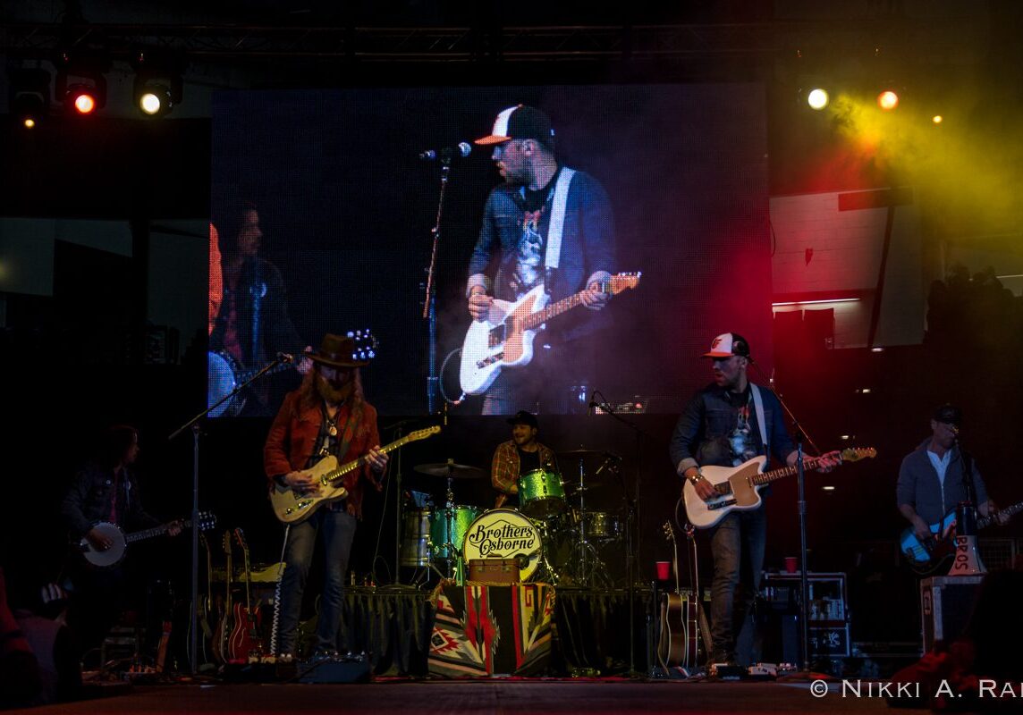 Band performing live on stage with instruments.