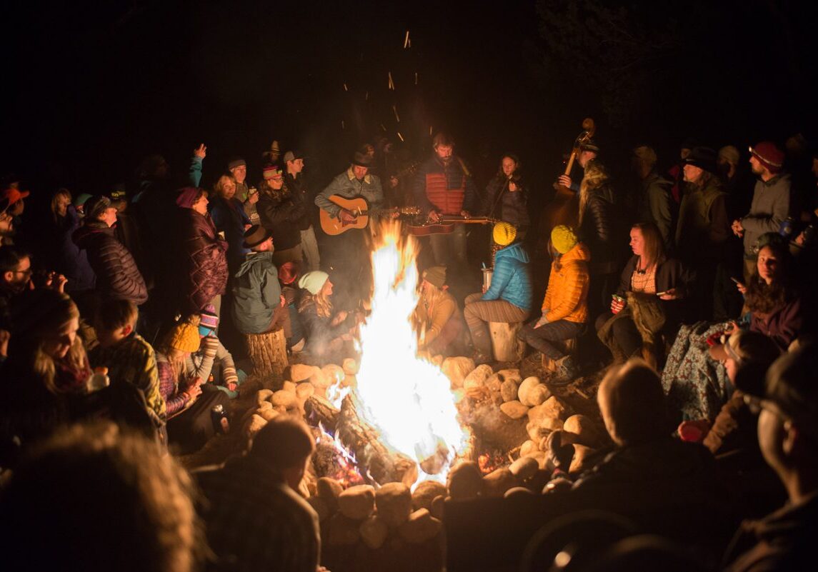 People gathered around a campfire at night.