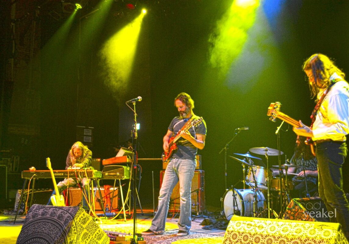 Band performing on stage under colorful lights.
