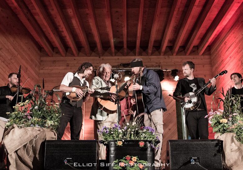 Musicians performing on a wooden stage.
