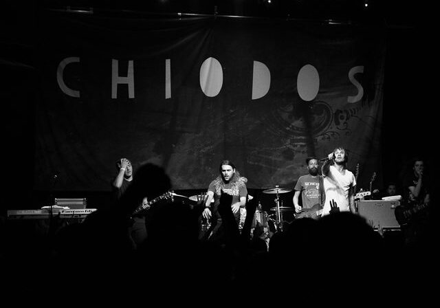 Band performing on stage under "Chiodos" banner.