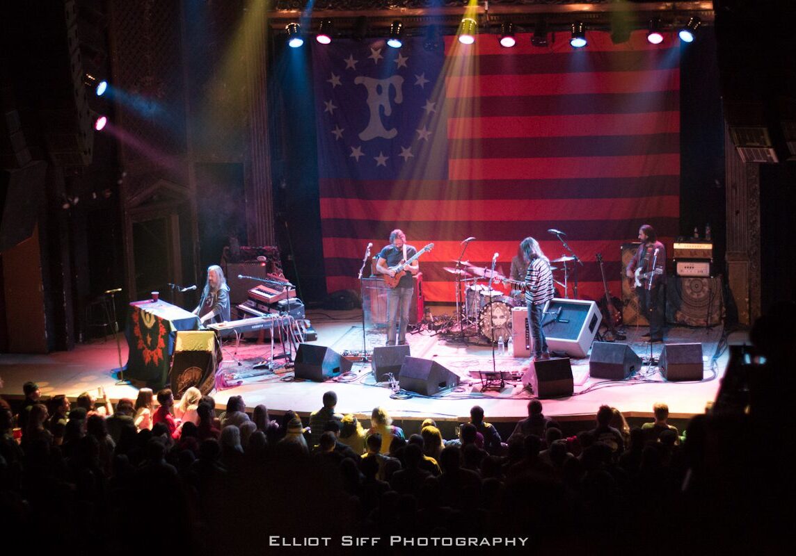 Live band performing on stage with audience.