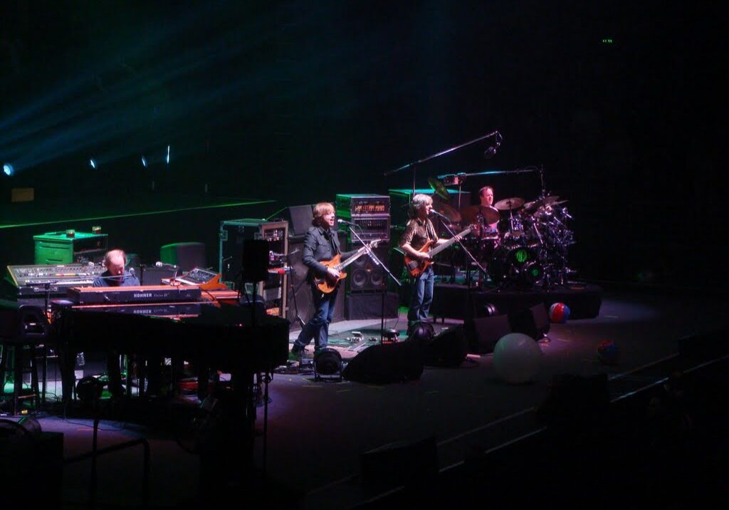 Band performing live on stage with instruments.