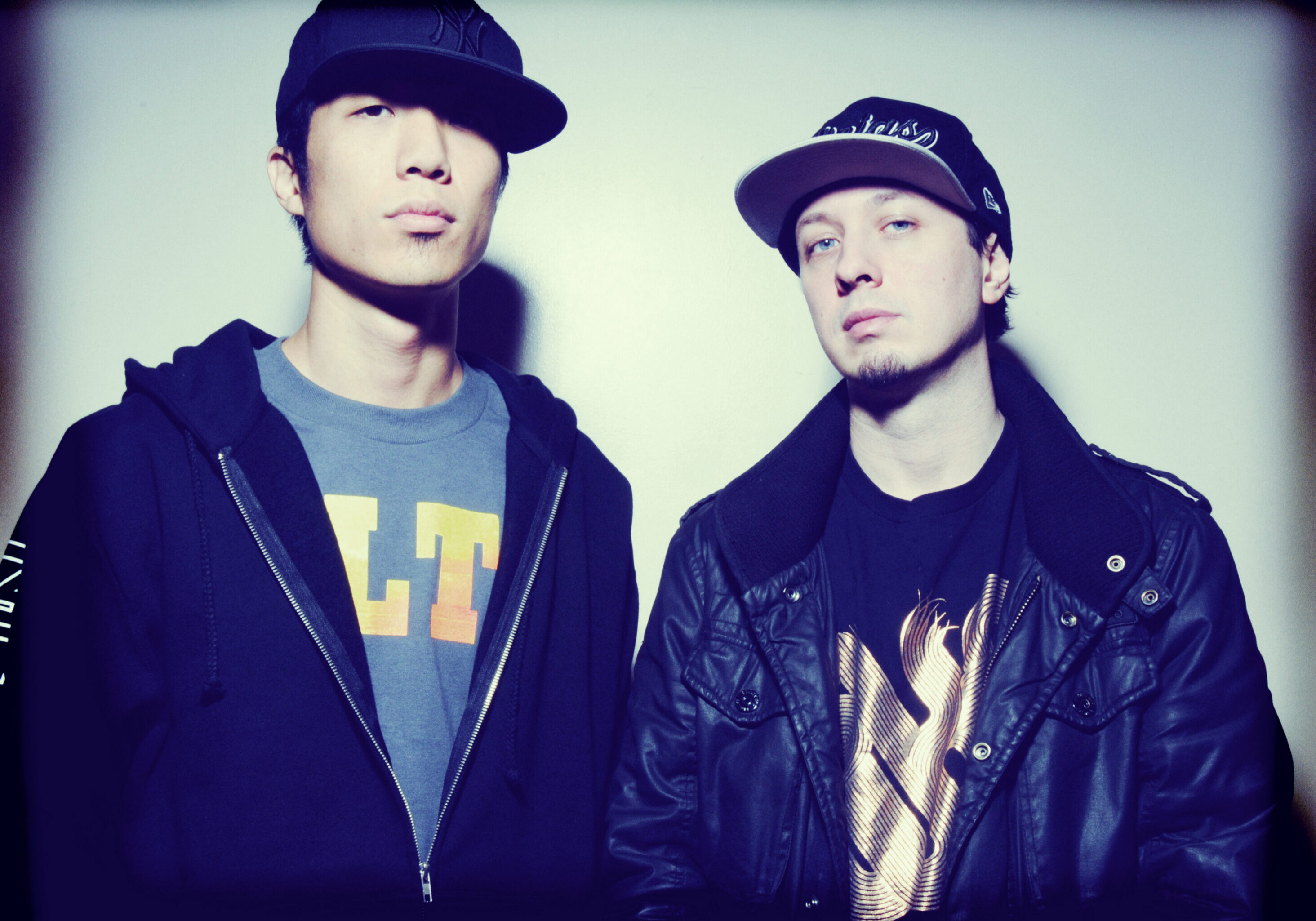 Two men wearing caps and casual jackets.