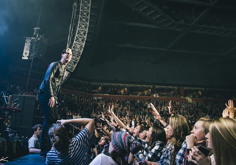 Concert performer engaging with enthusiastic audience.