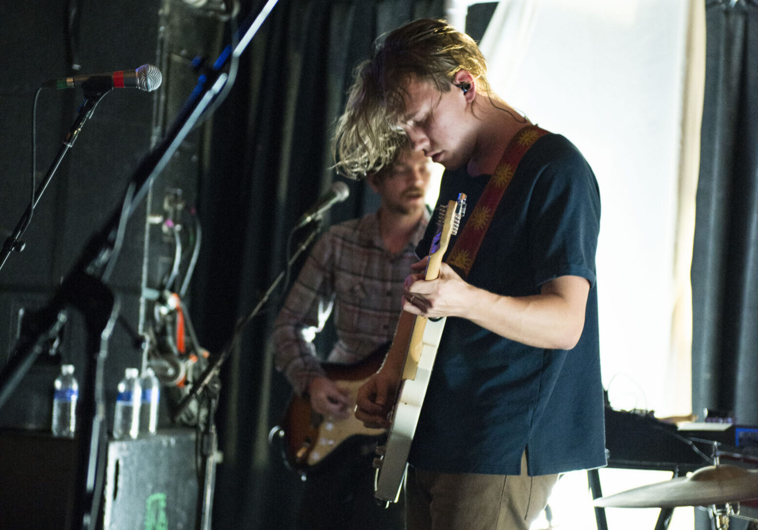 Musicians performing on stage with guitars.