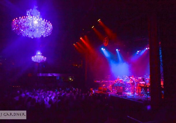 Concert stage with colorful lights and chandeliers.