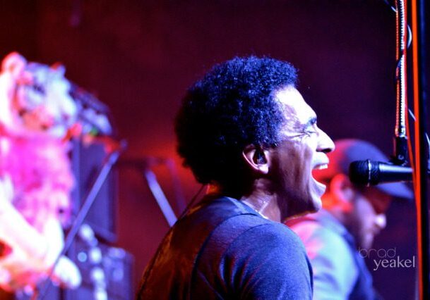 Musician singing passionately into a microphone.