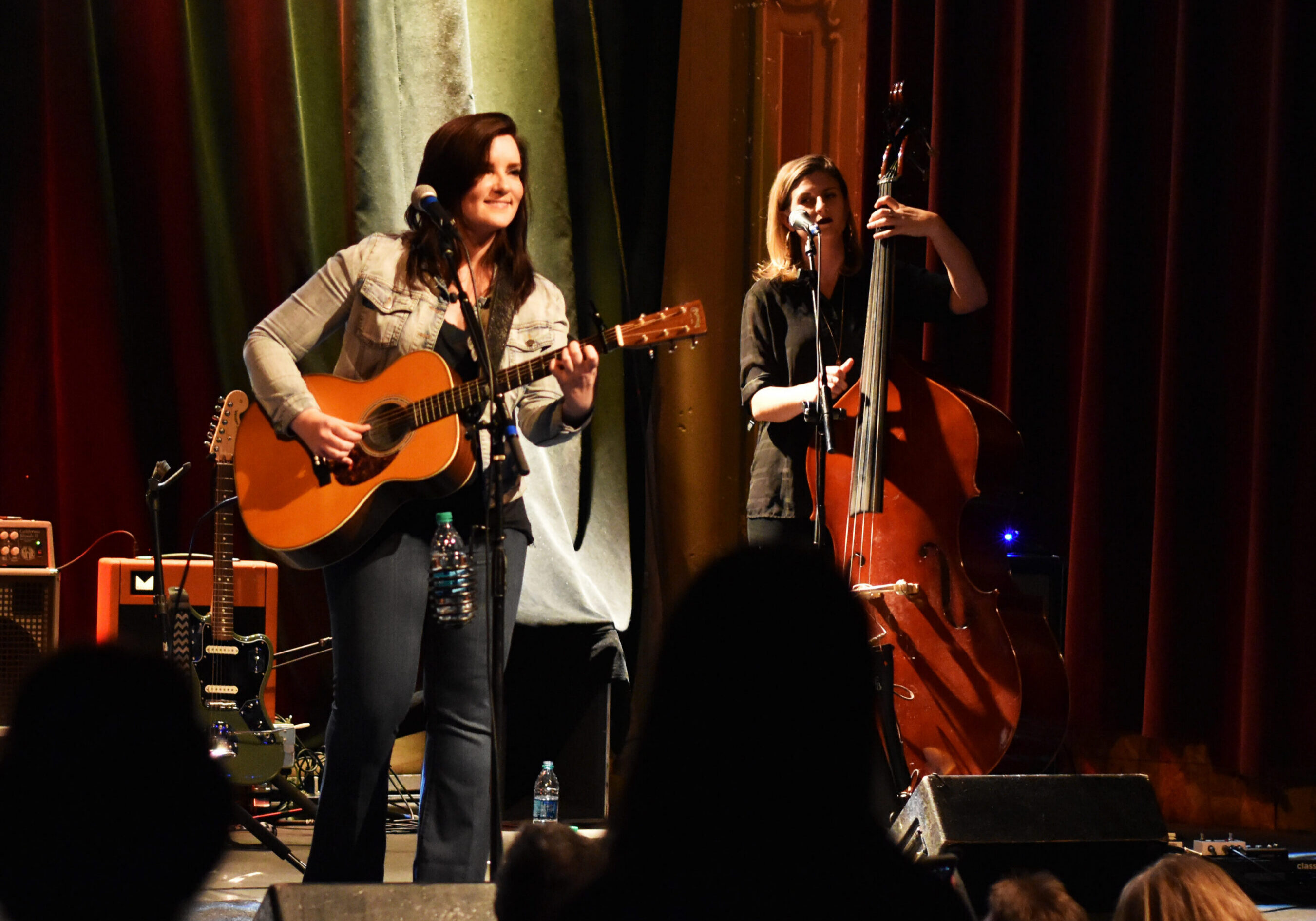 Musicians performing on stage with instruments.