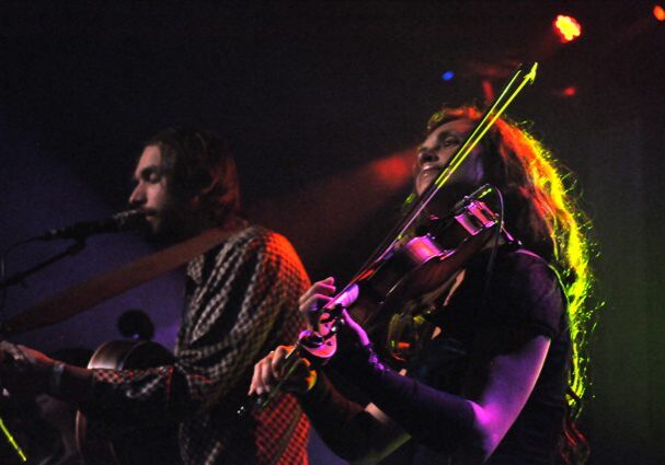 Musicians performing on stage with instruments.