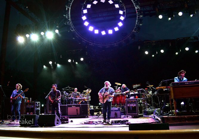 Band performing on stage with colorful lights.