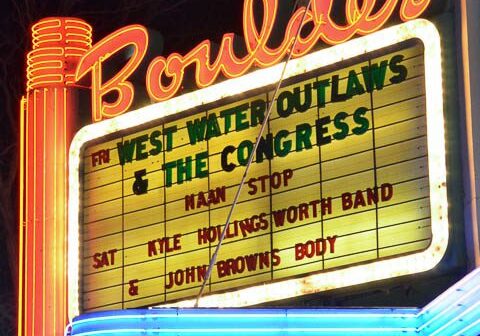 Neon theater marquee with event listings.