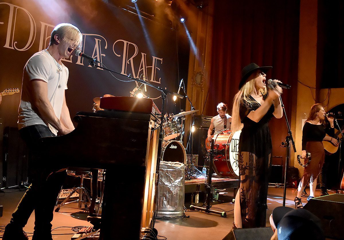 Band performing live on stage with instruments.