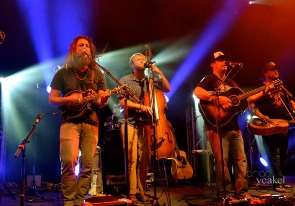 Band performing on stage with colorful lights.
