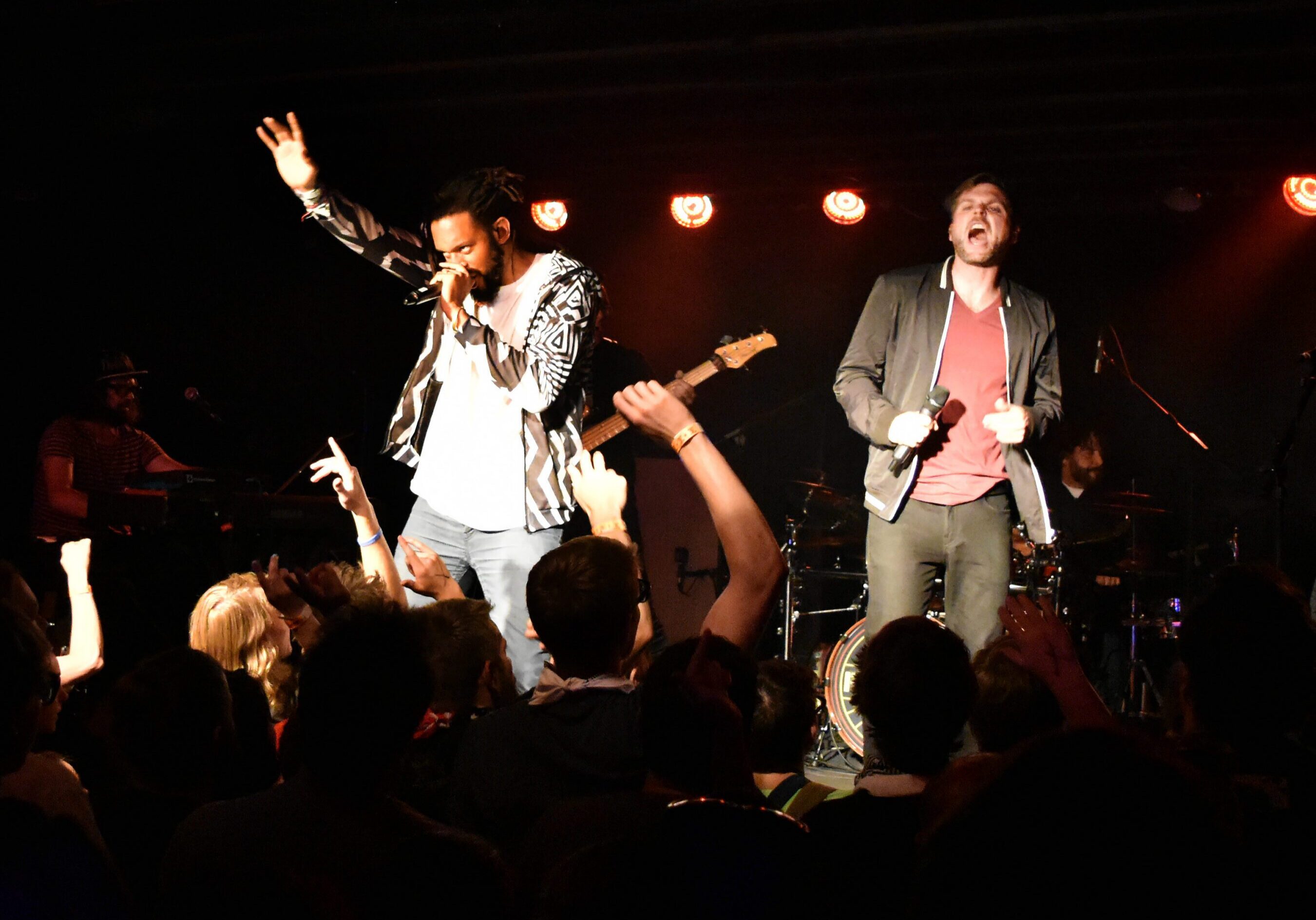 Live band performing on stage with crowd.