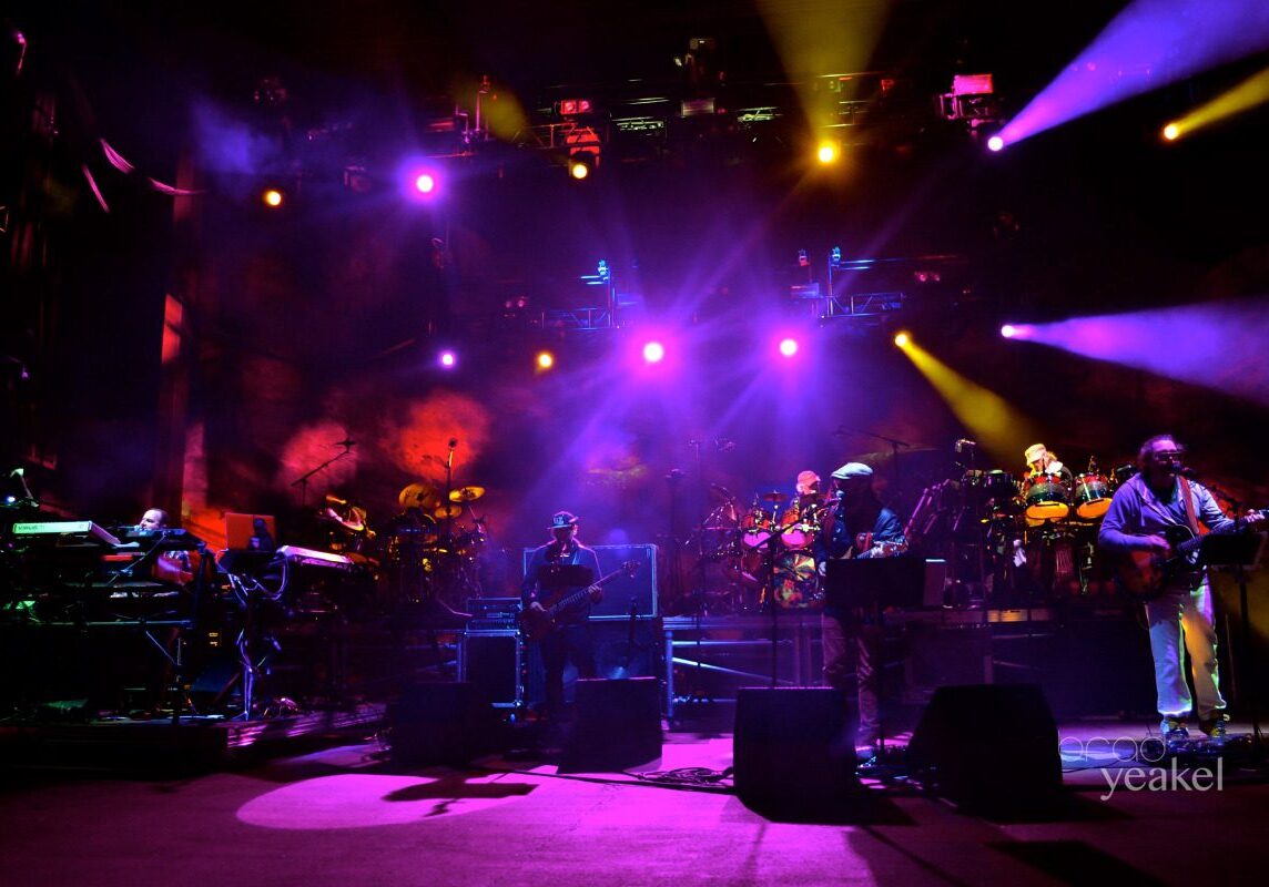 Band performing on stage with colorful lights.
