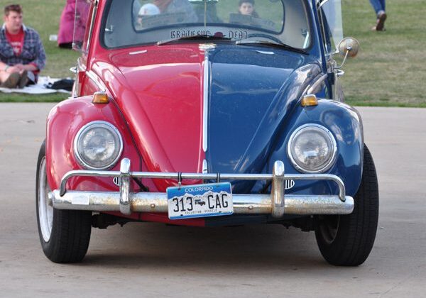 Red and blue vintage car parked outside.