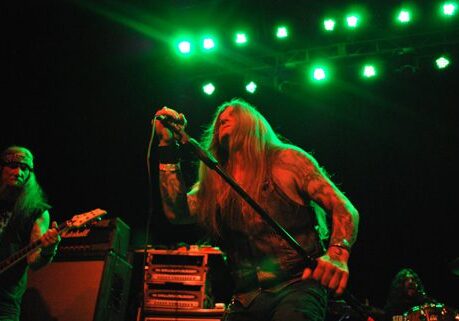 Rock band performing under green stage lights.