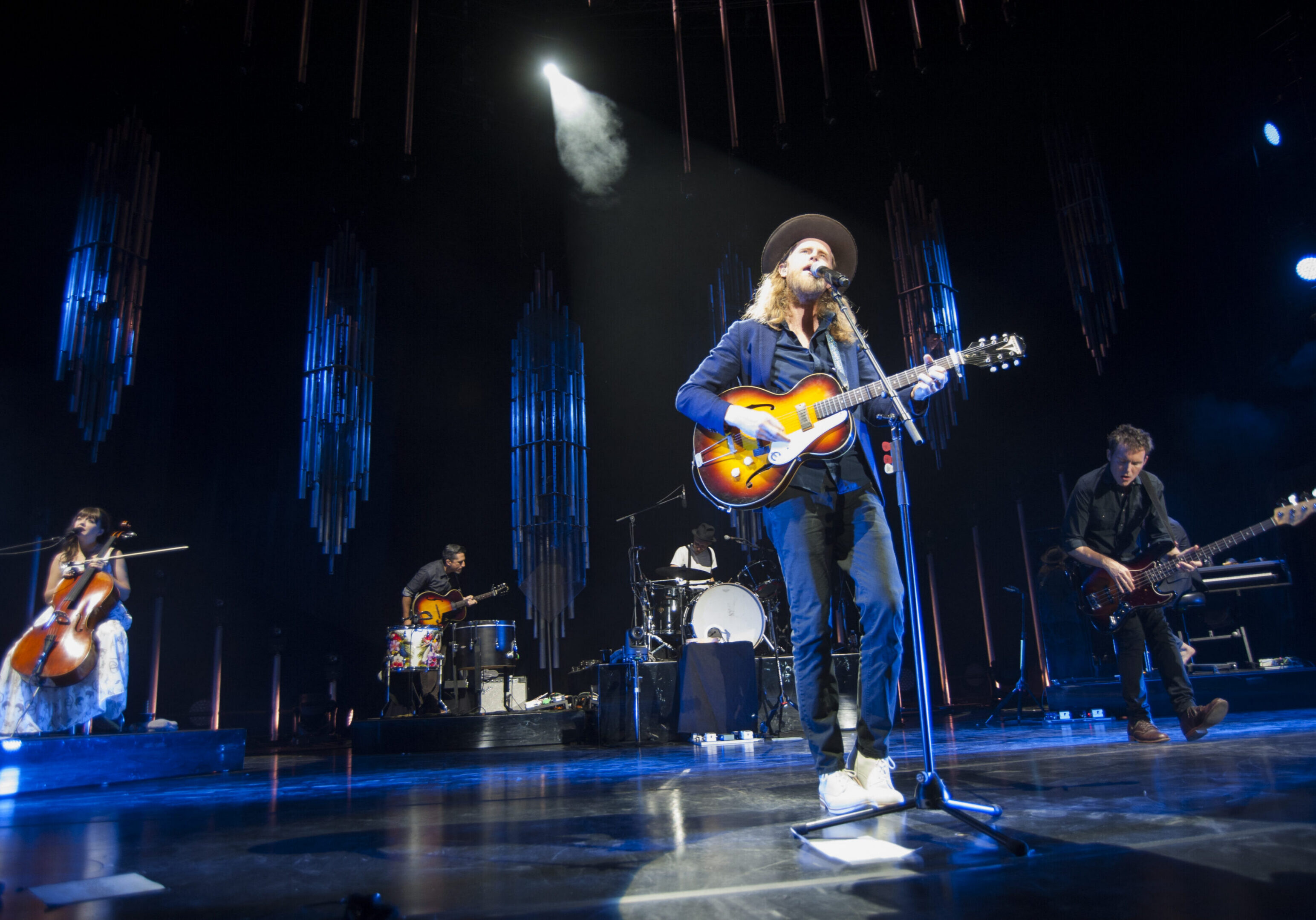 Band performing live on stage with instruments.