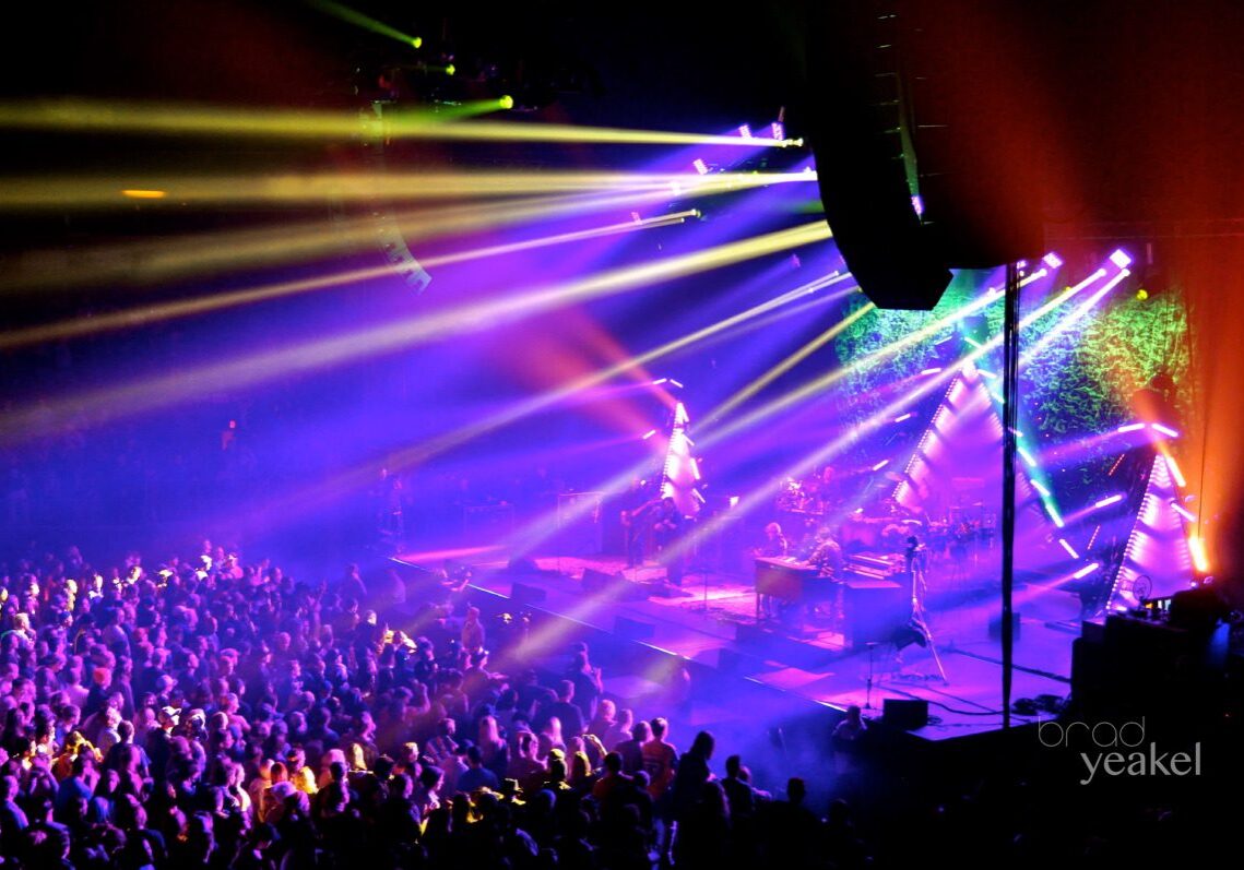 Concert with colorful stage lights and crowd.