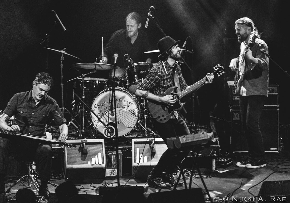 Band performing live on stage, black and white.