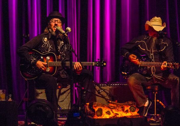 Musicians performing on stage with guitars.